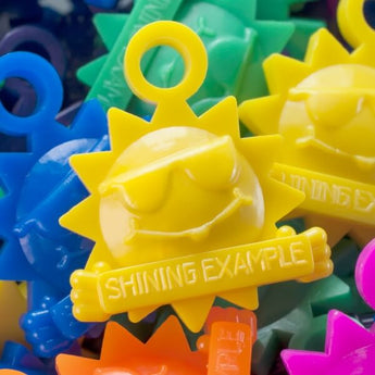 Shining Example by Fitness Finders: Colorful sun tokens w/ "Shining Example" slogan, character building student award